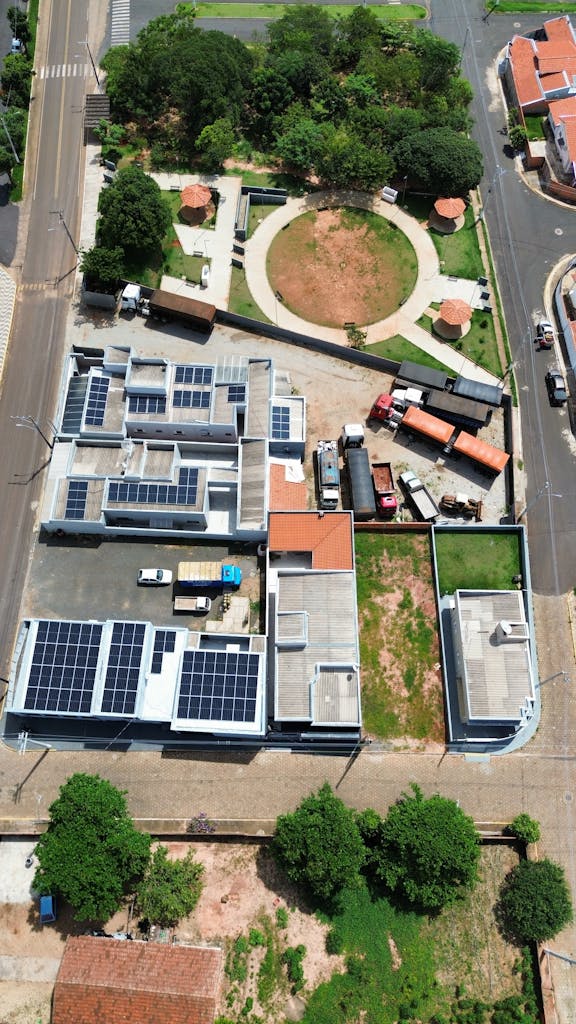 Aerial city view highlighting solar panels and green spaces on a sunny day.
